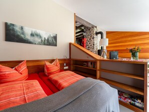 A cozy room with a bed, a wooden desk, a bookshelf, and a staircase leading to an upper level. - Holiday Home in Allrode With Garden (Thale)