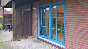 Ein Backsteinhaus mit blauer Fensterrahmung und einer Holztür.