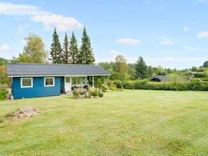 A blue house with a sloped roof, a front porch, and a well-maintained lawn. - 5 Person Holiday Home in Skibby (Skibby)