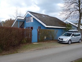 Une maison bleue avec une voiture garée devant.