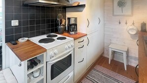 A compact kitchen with a stove, oven, and coffee maker. - 5 Person Holiday Home in Linneryd (Linneryd)