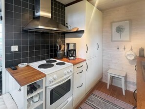 A compact kitchen with a stove, oven, and coffee maker. - 5 Person Holiday Home in Linneryd (Linneryd)