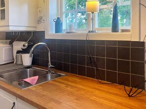 Eine Küche mit Spüle, Arbeitsfläche und Fenster.