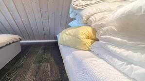 A room with a bed, a wooden wall, and a dark wooden floor. - 5 Person Holiday Home in Linneryd (Linneryd)