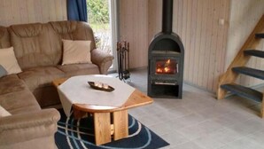 Un salon chaleureux avec un canapé, une table basse et un poêle à bois.