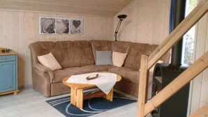 Un salon chaleureux avec un canapé en cuir marron, une table basse en bois et une cheminée.
