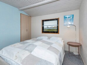 Relax in this serene bedroom with a large bed and a cozy reading nook.