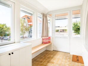 A bright room with large windows, a bench, a door, and a welcome mat. - Villa in Koksijde Near the Sea (Koksijde)