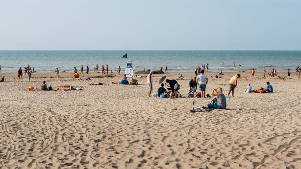 A sandy beach with people sunbathing and swimming. - Villa in Koksijde Near the Sea (Koksijde)