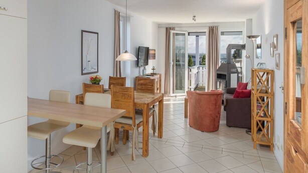 En moderne stue med spiseområde, pejs og balkon med udsigt.