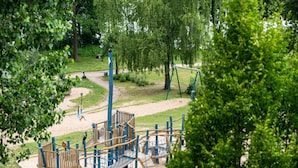 Un parque infantil con estructuras para escalar, toboganes y columpios.