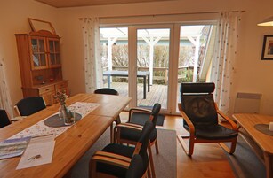 A dining area with a wooden table, chairs, and a cabinet.