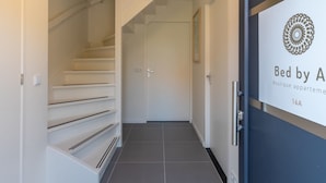 A modern staircase leading to a door with a sign reading "Bed by A Boutique apartment." - Apartment in Kortgene Near Grevelingenmeer (Kortgene)