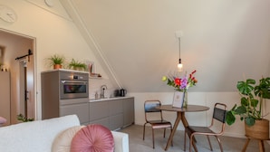 A modern loft apartment with a dining area, kitchenette, and a cozy seating area. - Apartment in Kortgene Near Grevelingenmeer (Kortgene)