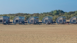 A row of beachside mobile homes with large windows and a sandy beach in the background. - Apartment in Kortgene Near Grevelingenmeer (Kortgene)