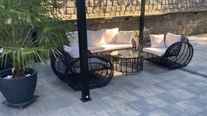An outdoor seating area with wicker furniture and a potted plant. - Holiday Home in Miedzyzdroje for 8 Persons (Miedzyzdroje)