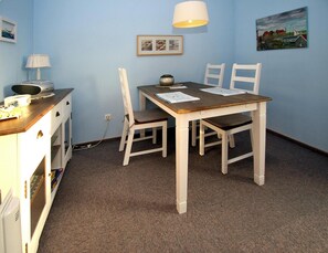Cozy room with a wooden table, two chairs, and a small cabinet.