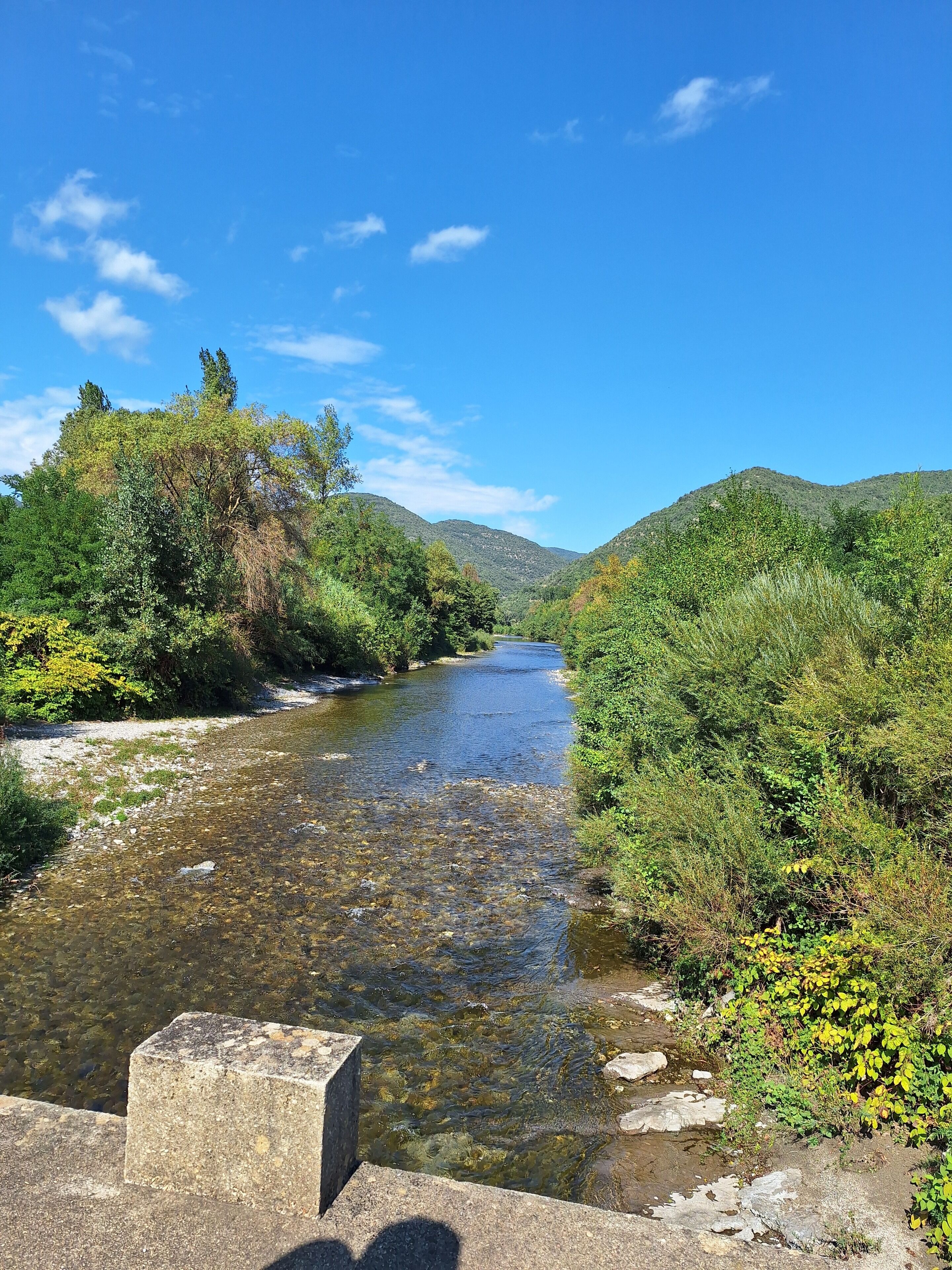 A river flowing through a valley with hills on either side.