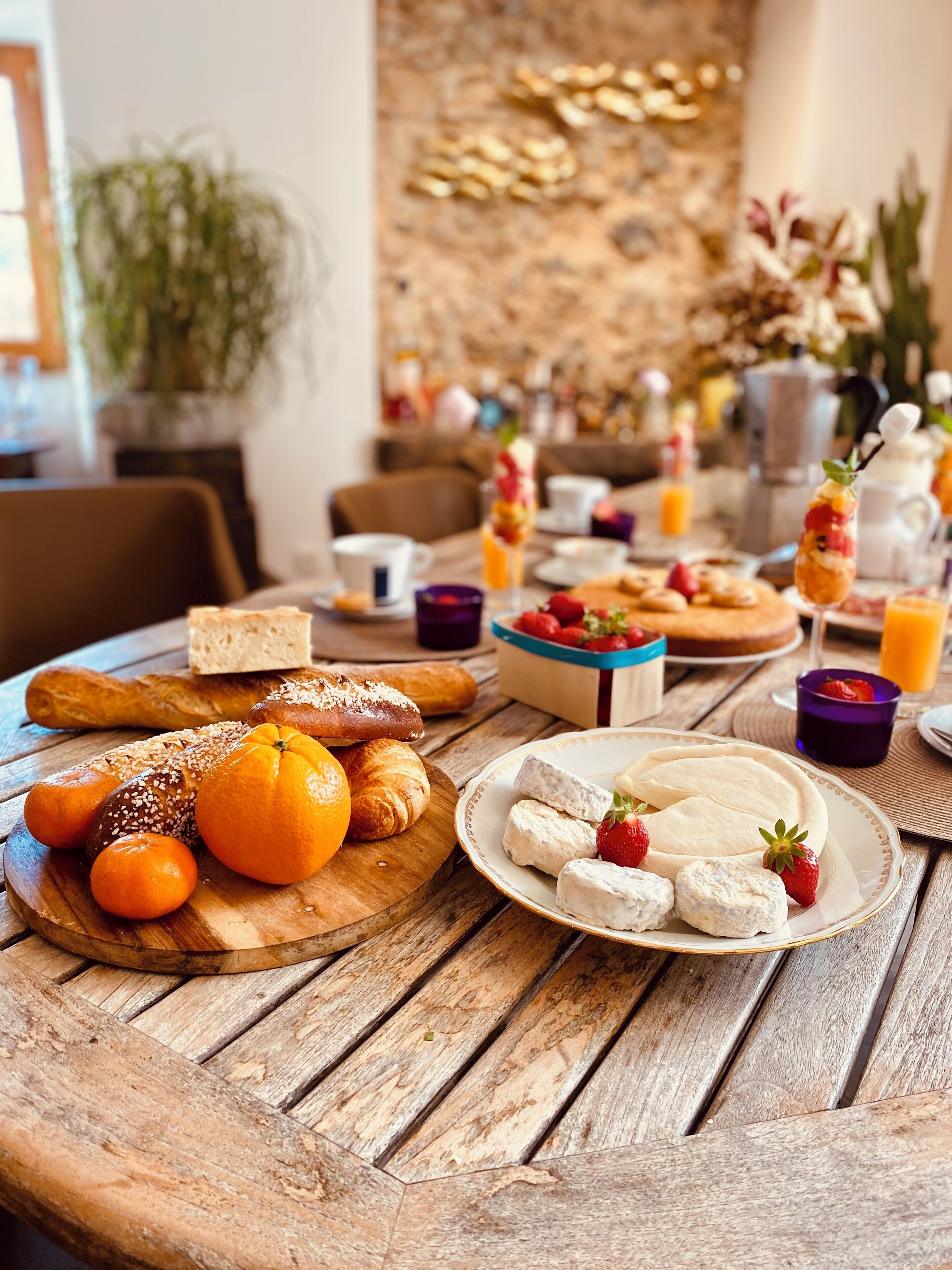 Une table de petit-déjeuner avec des viennoiseries, des fruits et des boissons.
