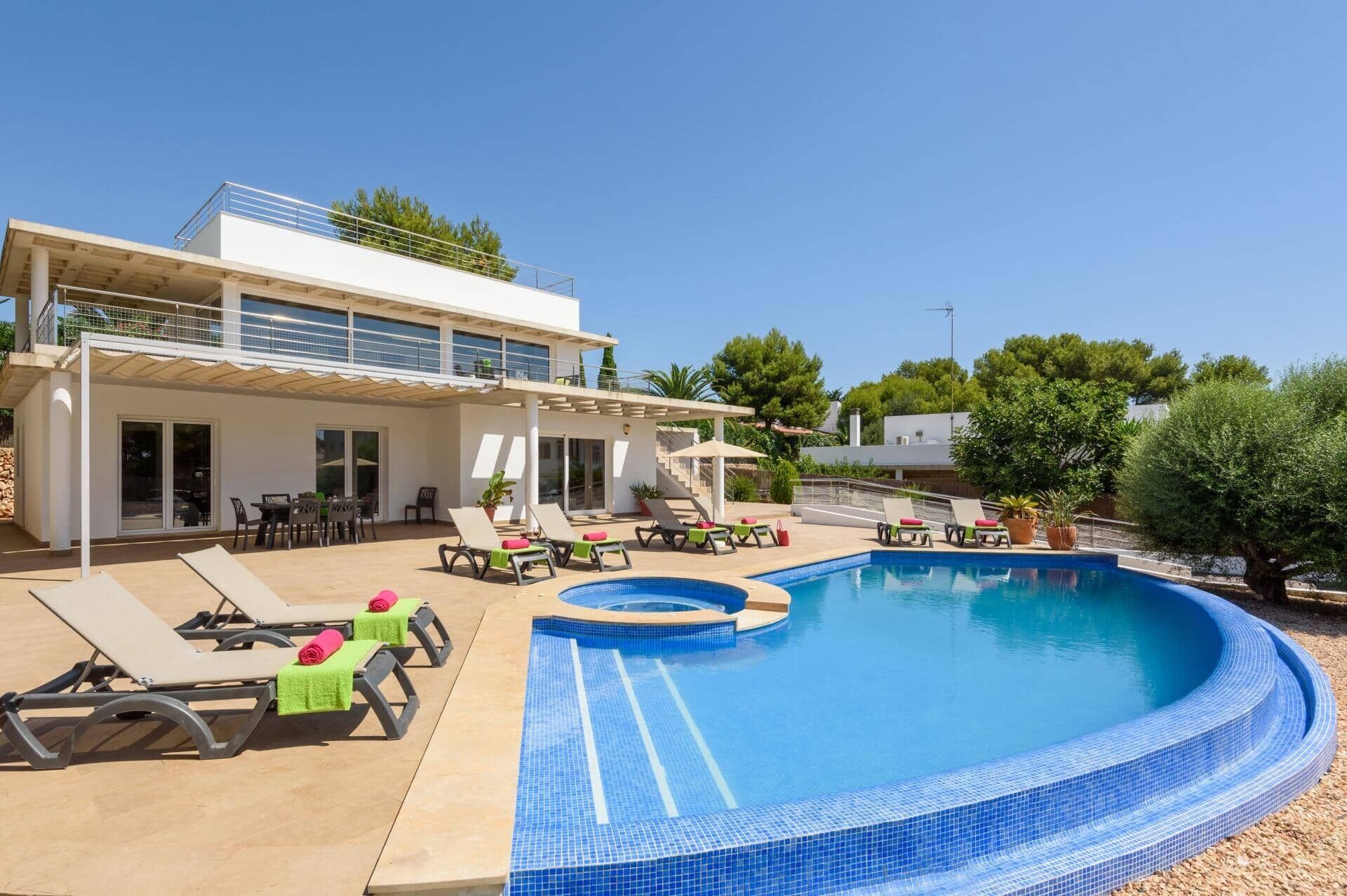 A modern two-story building with a swimming pool, outdoor seating, and a covered patio area.