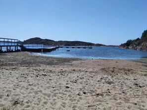 A sandy beach with a pier extending into the water. - 4 Star Holiday Home in Kyrkesund (Kyrkesund)