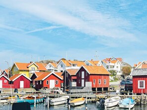 A waterfront with colorful buildings and boats docked at a pier. - 4 Star Holiday Home in Kyrkesund (Kyrkesund)