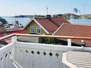 A coastal residential area with houses, a wooden deck, and a view of the sea. - 4 Star Holiday Home in Kyrkesund (Kyrkesund)