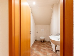 A small, narrow bathroom with a toilet, sink, and shower. - Magnificent Flat With Panoramic Views (Gaschurn)