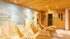 Interior de madera con un mural de paisaje, bancos de madera y una zona de recepción con un reloj y señalizaciones.