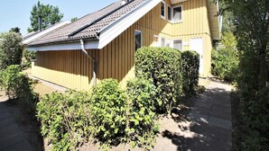 Yhden kerroksen korkuinen keltainen rakennus, jossa on kalteva katto ja savupiippu.