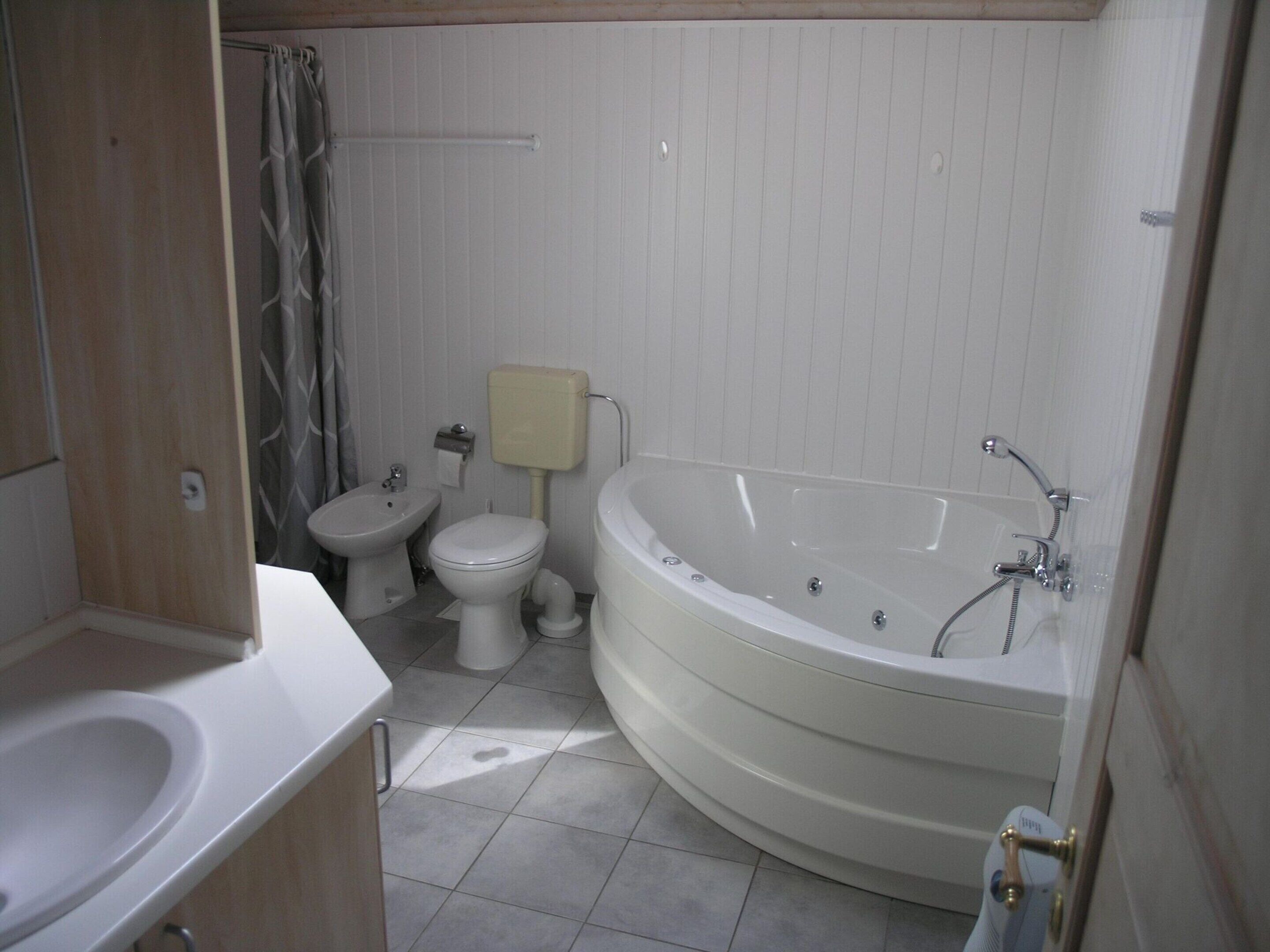 Een badkamer met een wastafel, toilet en bad.