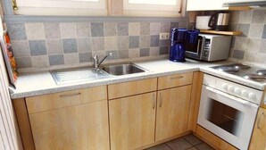 Eine Küche mit Spüle, Herd und Mikrowelle.
