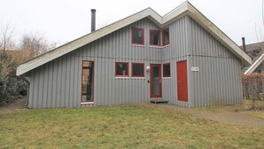A two-story building with a grey exterior and red-framed windows. - Exklusives Skandinavisches Ferienhaus (Mirow)