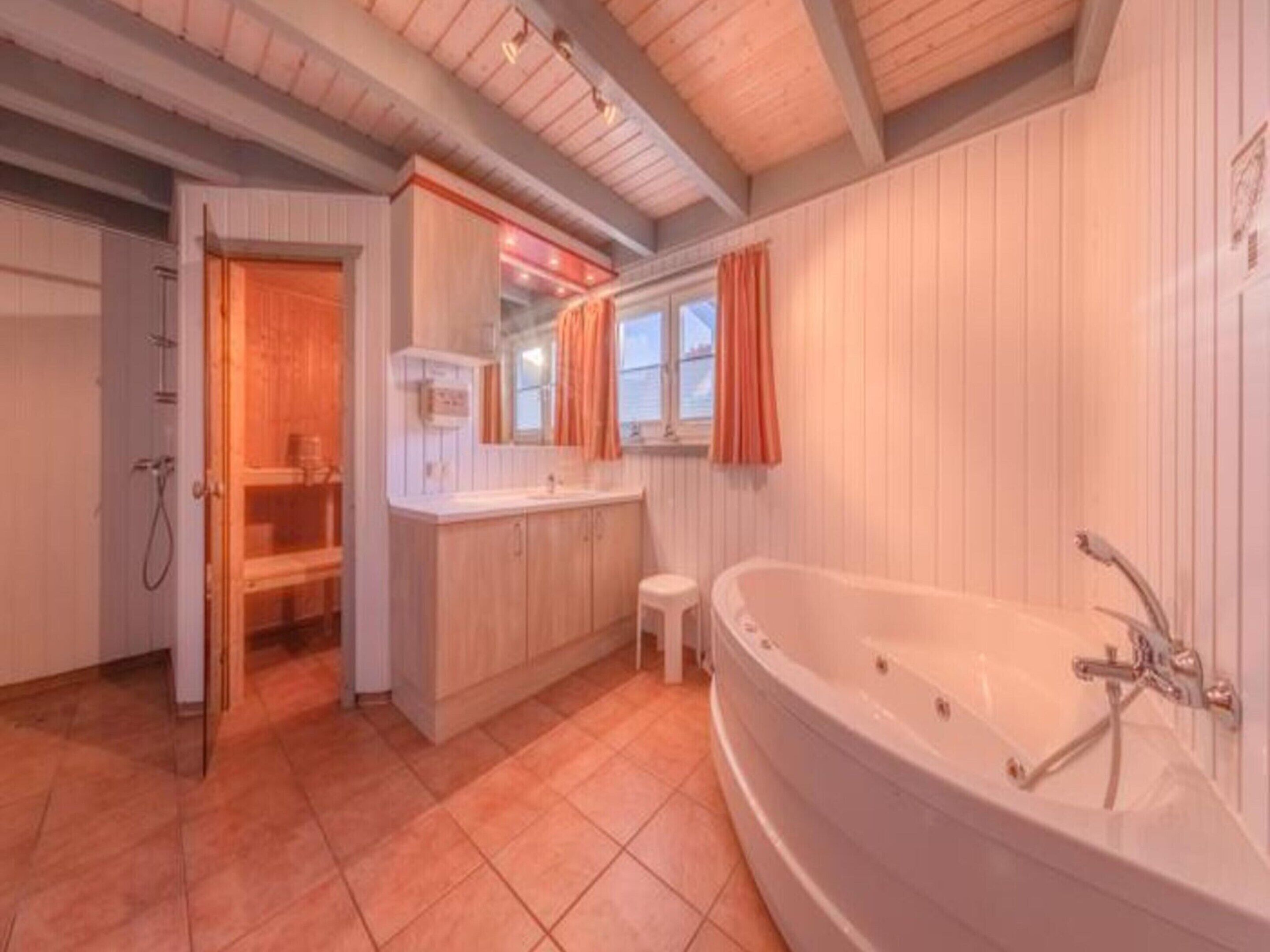 A bathroom with a freestanding bathtub, a vanity with a mirror, and a shower area.