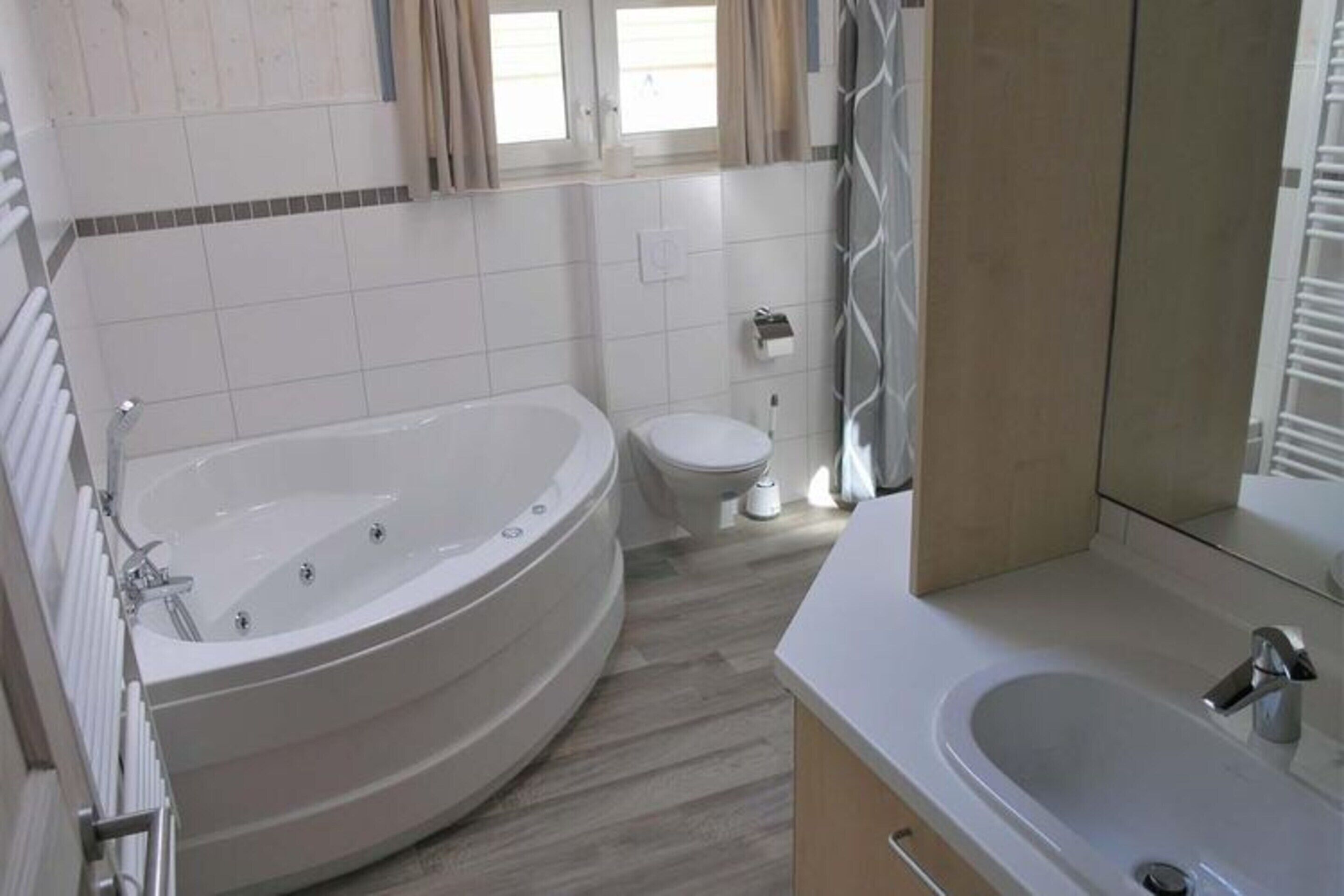 A modern bathroom with a freestanding bathtub, a toilet, and a sink.