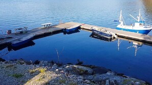A calm lake with a dock, a small boat, and a larger fishing boat. - 4 Star Holiday Home in Naustbukta (Nærøysund)