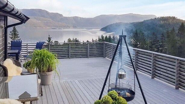 A deck with outdoor furniture, potted plants, and a grill. - 4 Star Holiday Home in Naustbukta (Nærøysund)