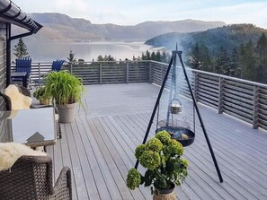 A deck with outdoor furniture, potted plants, and a grill. - 4 Star Holiday Home in Naustbukta (Nærøysund)