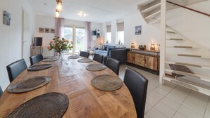 A modern kitchen with a wooden dining table, chairs, and a staircase. - Spacious Holiday Home With Sauna Near Beach (Wemeldinge)