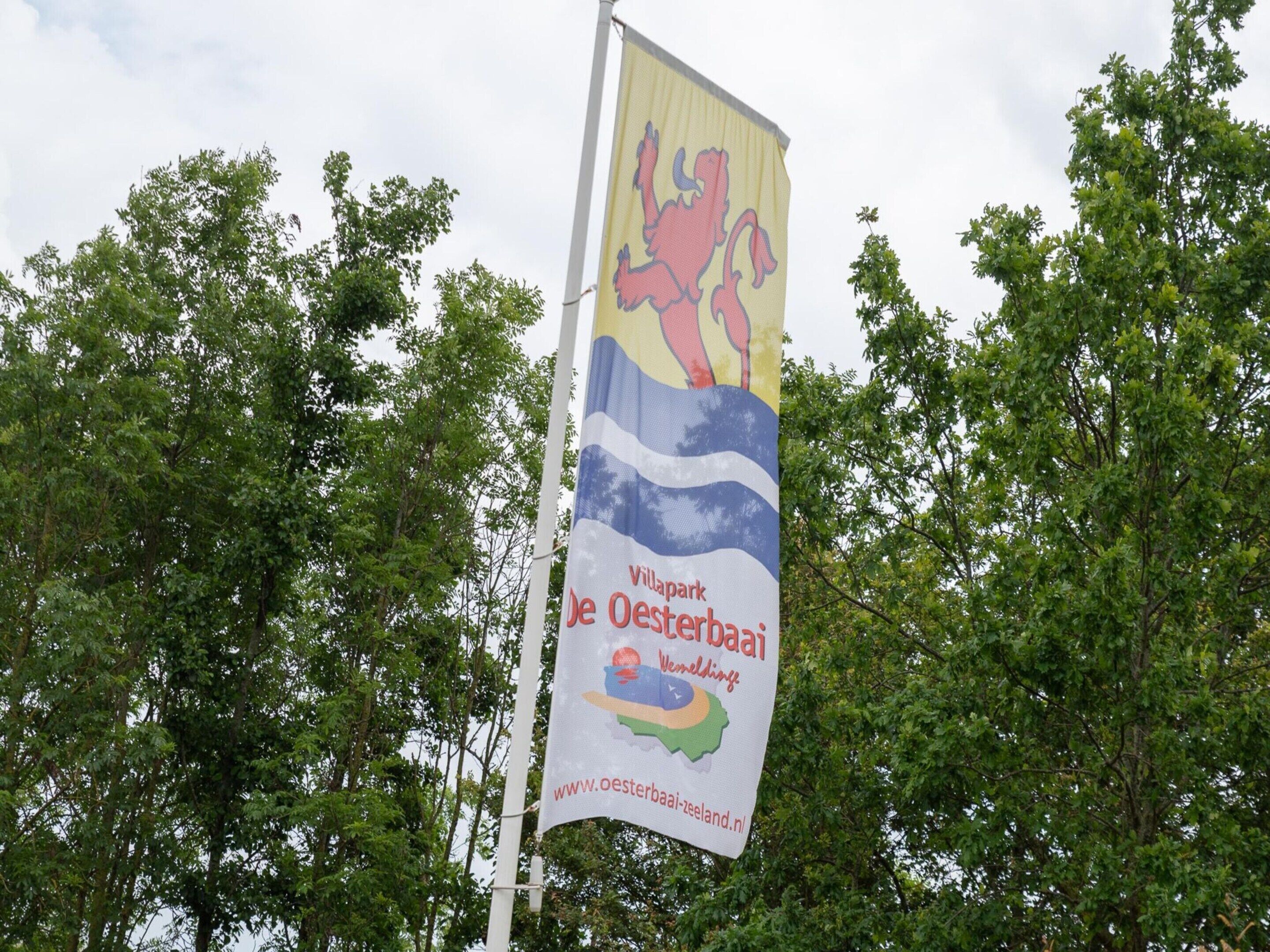 Een vlag met een logo en tekst voor Villapark De Oesterbaai.
