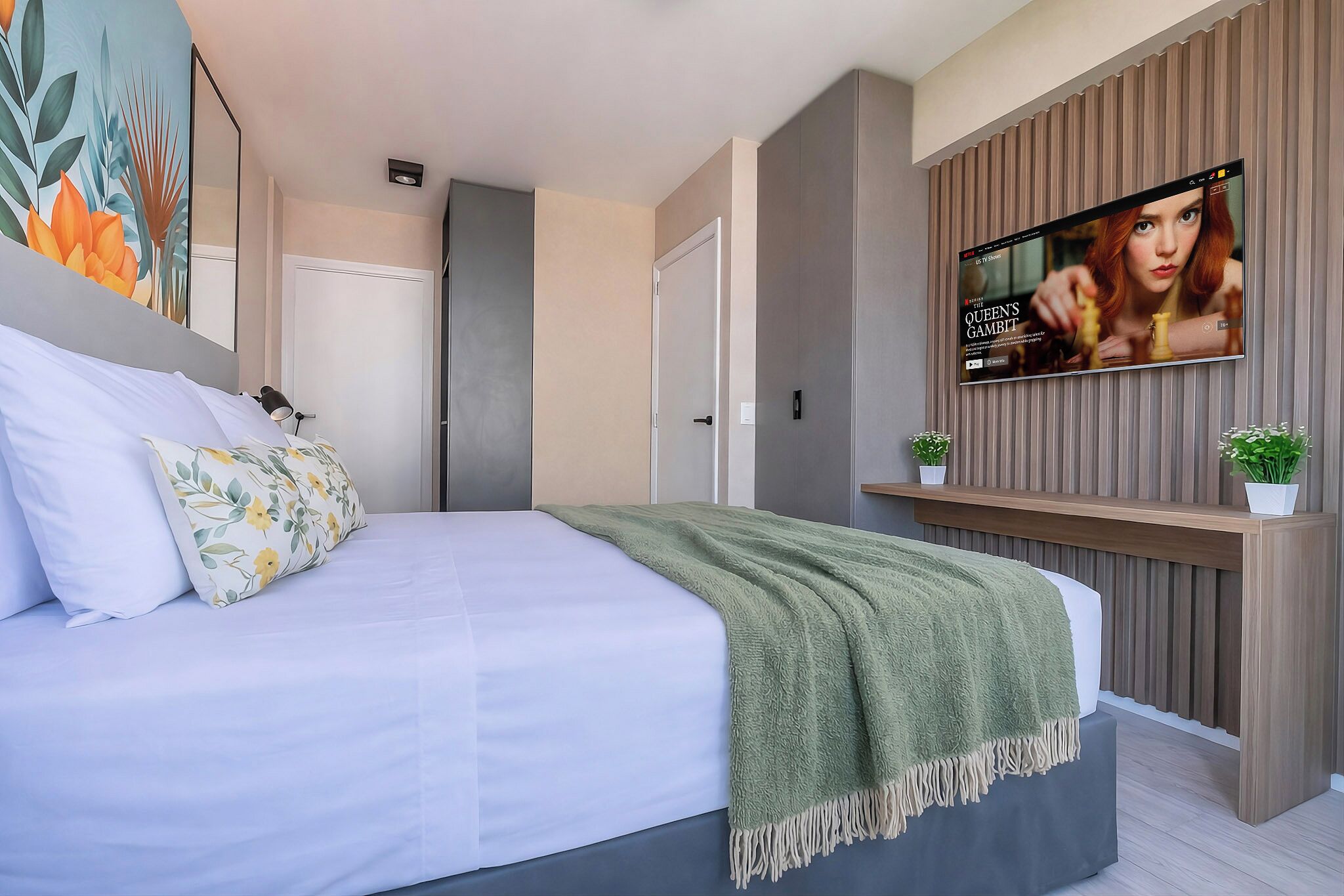 Une chambre à coucher moderne avec un lit, un téléviseur fixé au mur et une porte.