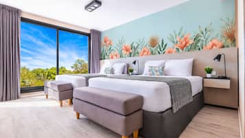 A modern bedroom with a large bed, a view of the outdoors, and a tropical-themed wall mural.