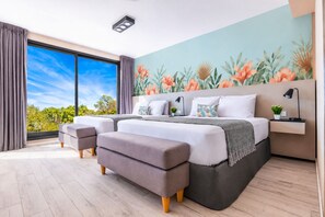 A modern bedroom with a large bed, a view of the outdoors, and a tropical-themed wall mural. - Family Apartments in Palermo - by BueRentals (Buenos Aires)