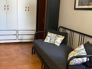 Quarto com cama, guarda-roupa e porta.