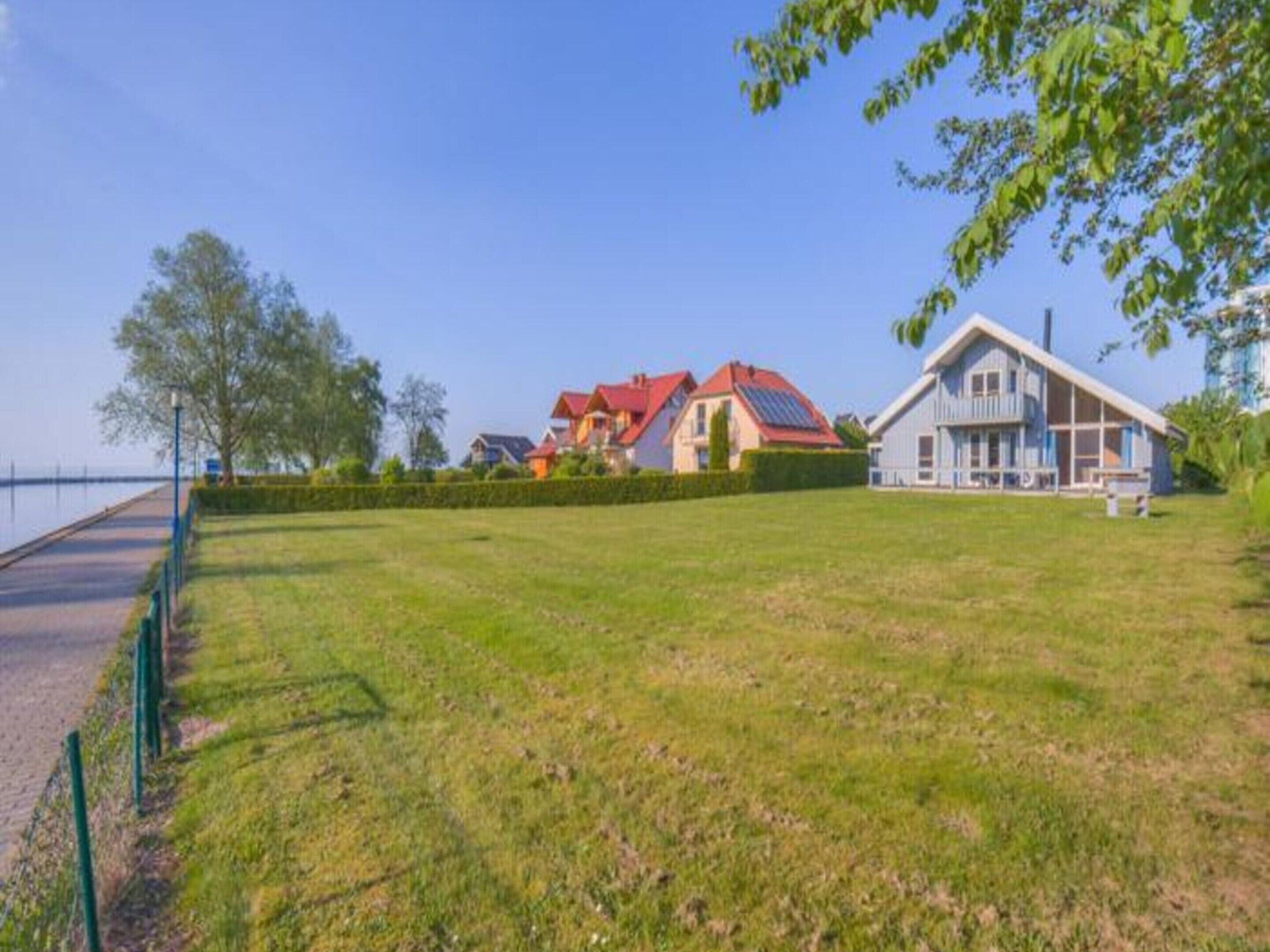 A residential area with houses, a grassy field, and a paved path.