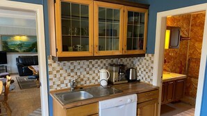 A compact kitchen with wooden cabinets, a Bosch dishwasher, and a tiled backsplash. - 6 Person Holiday Home in Storslett (Nordreisa)