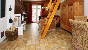 A rustic interior with a wooden staircase, a fireplace, and a dining area. - Ferienhaus in Wieda mit Garten (Walkenried)