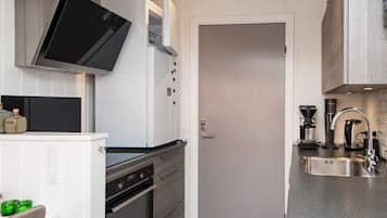 A modern kitchen with a built-in oven, a microwave, and a coffee maker.