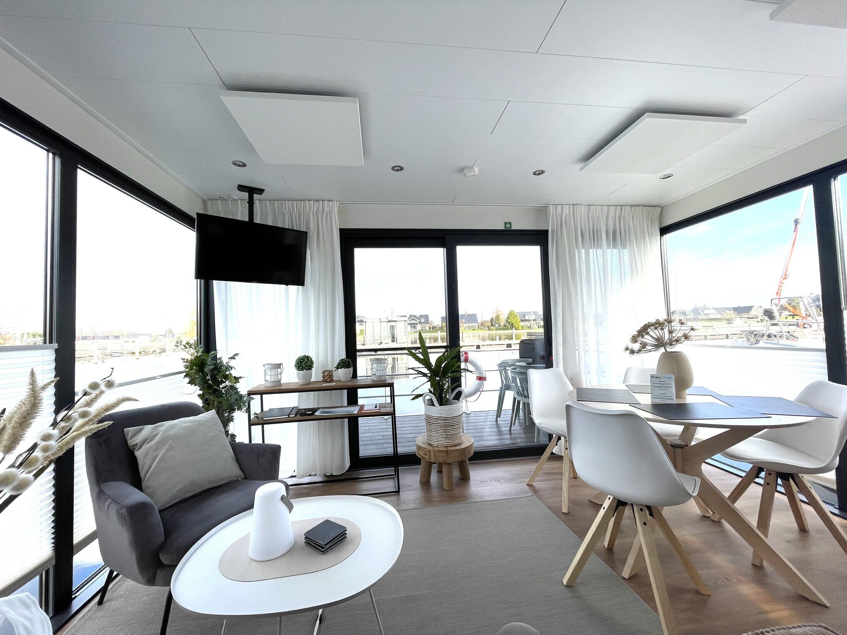 Uma sala de estar moderna com sofá, mesa de centro e área de jantar.