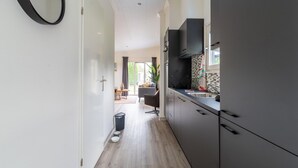 Una cucina moderna con mobili scuri, una cappa aspirante nera e un'ampia finestra.